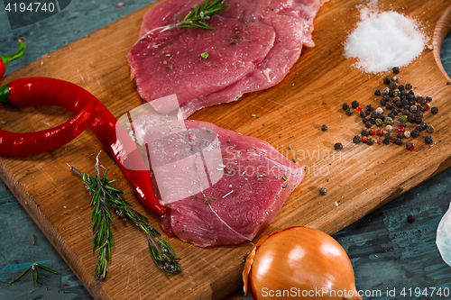 Image of Pieces of raw pork steak with spices and herbs rosemary