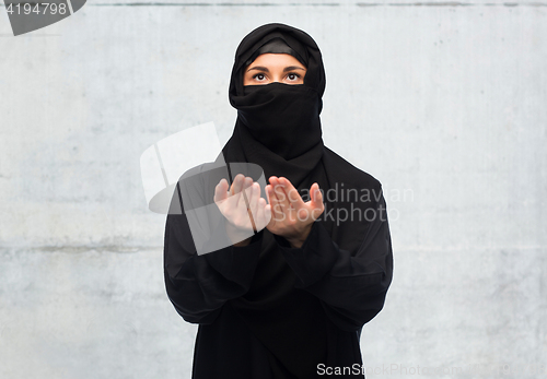 Image of praying muslim woman in hijab over white