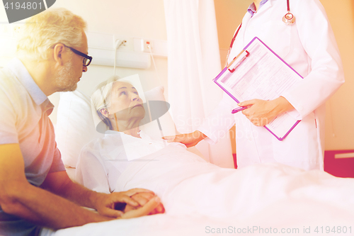 Image of senior woman and doctor with clipboard at hospital