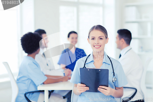 Image of happy doctor over group of medics at hospital