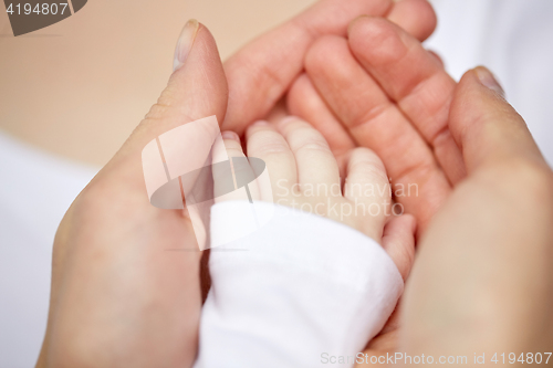 Image of close up of mother and newborn baby hands