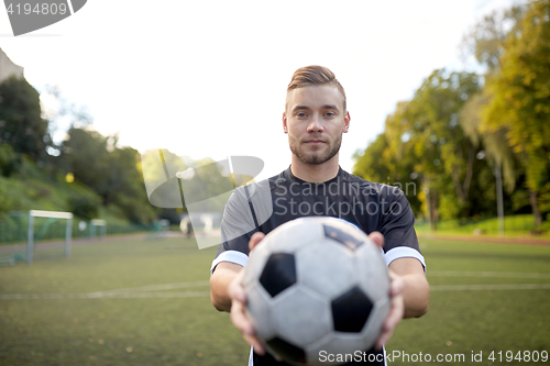 Image of soccer player with ball on football field