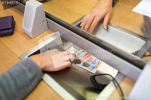 Image of clerk giving cash money to customer at bank office