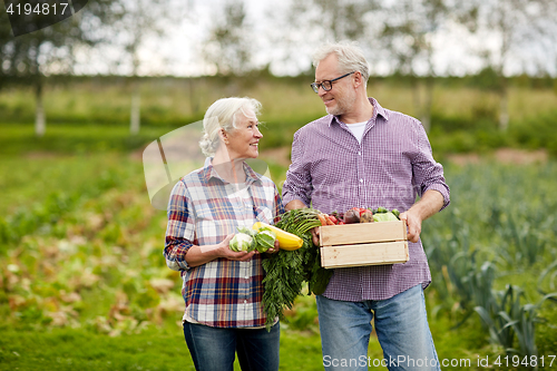 Image of senior couple with box of vegetables on farm