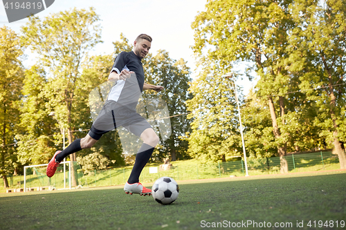 Image of soccer player playing with ball on football field