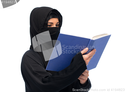 Image of muslim woman in hijab reading book over white