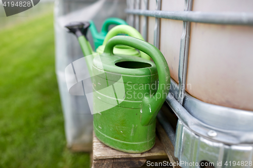 Image of watering cans at farm water tank