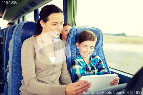 Image of happy family with tablet pc sitting in travel bus