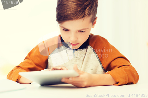 Image of close up of boy with tablet pc computer at home