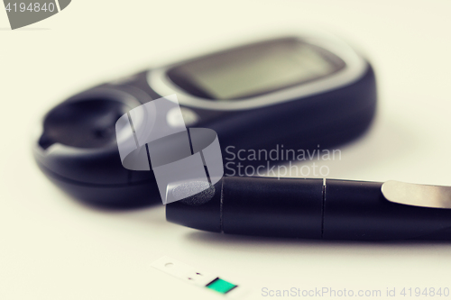 Image of close up of glucometer and blood sugar test stick