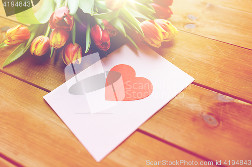 Image of close up of flowers and greeting card with heart