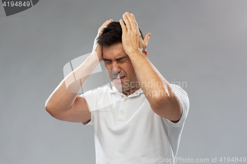 Image of unhappy man suffering from head ache