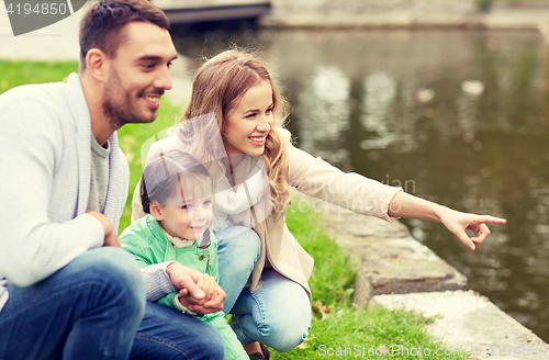 Image of happy family walking in summer park