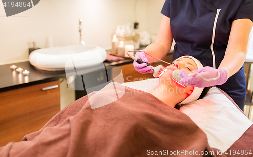 Image of young woman having face microdermabrasion at spa