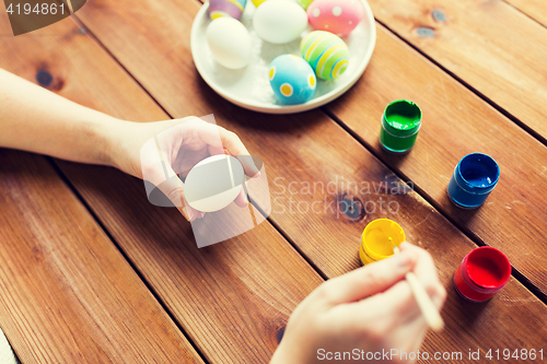 Image of close up of woman hands coloring easter eggs