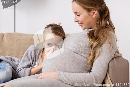 Image of pregnant woman and girl talking to baby in belly