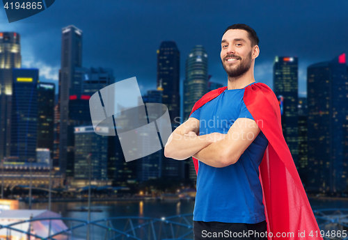 Image of happy man in red superhero cape over night city