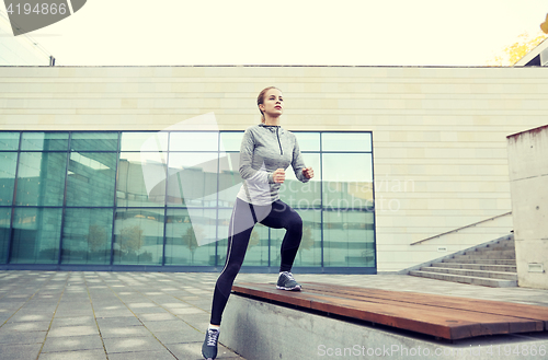 Image of woman making step exercise on city street bench