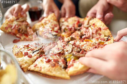 Image of close up of hands taking pizza slices