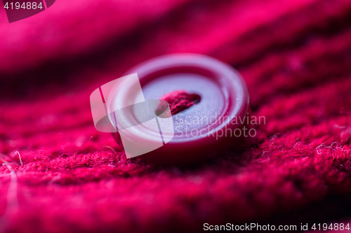 Image of close up of button sewn to knitted item