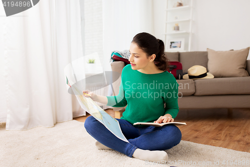Image of woman with map planning her travel at home