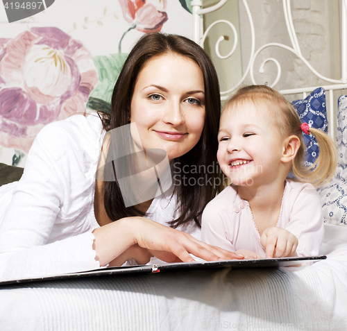 Image of mother with daughter together in bed smiling, happy family close up, lifestyle people concept, cool real modern family playing