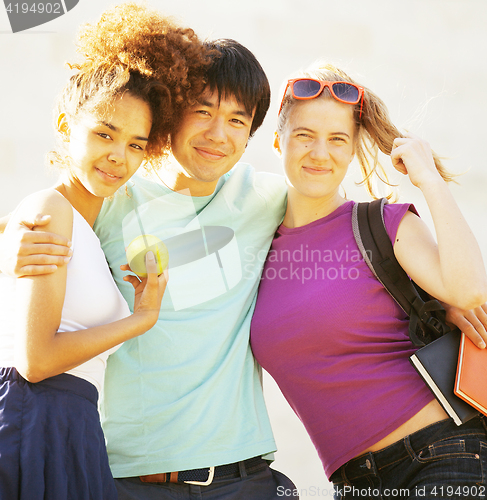 Image of cute group of teenages at the building of university with books huggings, diversity nations