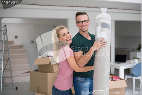 Image of couple carrying a carpet moving in to new home