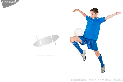 Image of Young boy with soccer ball doing flying kick