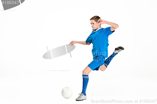 Image of Young boy with soccer ball doing flying kick