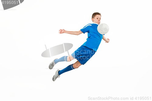 Image of Young boy with soccer ball doing flying kick