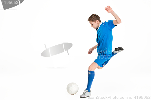Image of Young boy with soccer ball doing flying kick