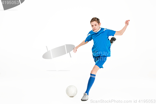 Image of Young boy with soccer ball doing flying kick