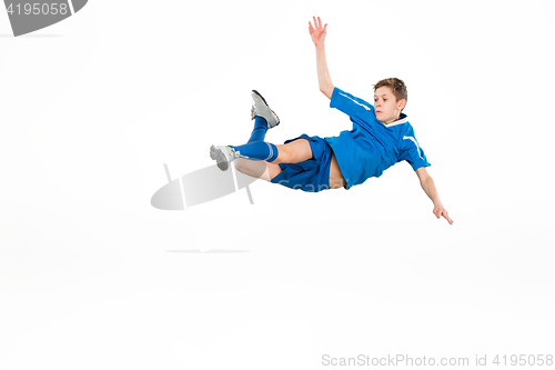 Image of Young boy with soccer ball doing flying kick