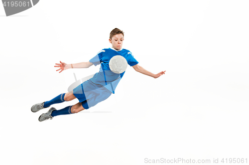 Image of Young boy with soccer ball doing flying kick