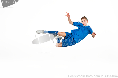 Image of Young boy with soccer ball doing flying kick