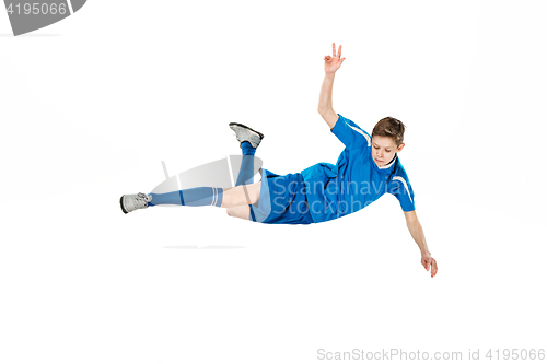 Image of Young boy with soccer ball doing flying kick