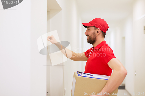 Image of delivery man with parcel box knocking on door