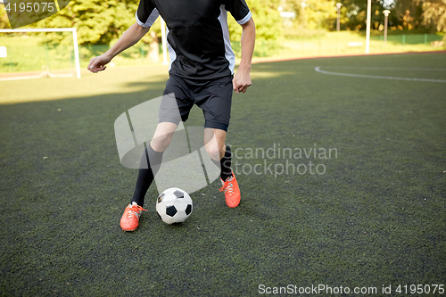 Image of soccer player playing with ball on football field