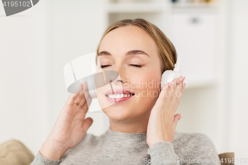 Image of woman with headphones listening to music at home