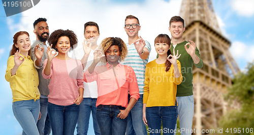 Image of international people showing ok over eiffel tower