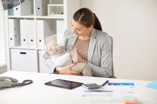 Image of happy businesswoman with baby working at office