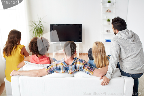 Image of happy friends watching tv at home