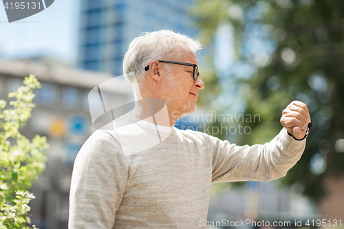 Image of senior man checking time on his wristwatch