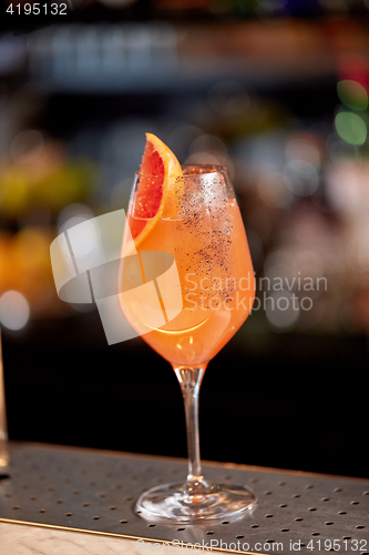 Image of glass of grapefruit cocktail at bar