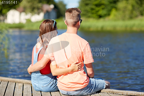 Image of happy teenage couple hugging on river summer berth