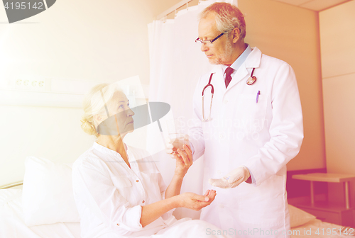 Image of doctor giving medicine to senior woman at hospital