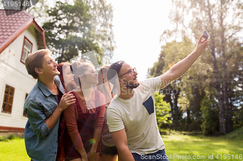 Image of friends taking selfie at party in summer garden