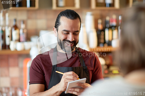 Image of man or waiter serving customer at bar