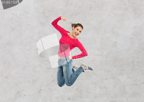 Image of smiling young woman jumping in air